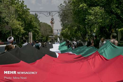 پرچم ۲۰۰ متری فلسطین توسط زنجیره انسانی و با رعایت پروتکل‌های بهداشتی از سه راهی مصلی به سمت میدان س ...
